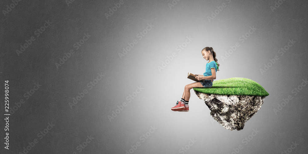 Naklejka premium Concept of careless happy childhood with girl reading book
