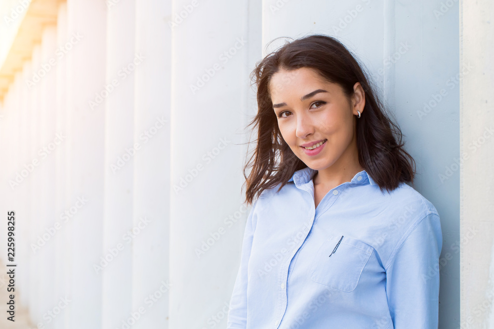 Close up portrait of a beautiful brunette woman on a background of gray columns. Happy smile, Close up portrait of a beautiful brunette woman on a background of gray columns. Happy smile,