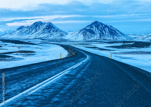 Road to the snow-capped mountains at twilight in winter. . The Ring Road (Route 1) of Iceland, between Egilsstadir and Akureyri. . Natural landscape in Northeast of Iceland.