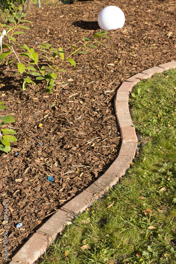 Rindenmulch am Wegrand verteilen Rindenmulch am Wegrand verteilen