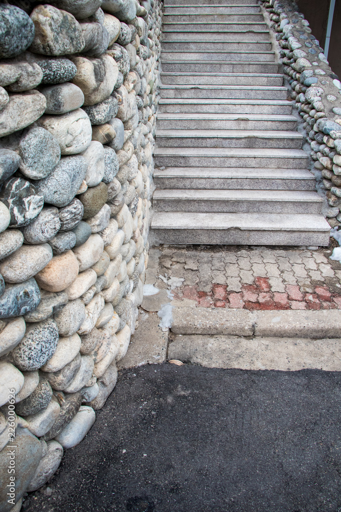 Fototapeta schody i ściana z kamienia żwirowego. Piękne schody skalne i ściana skalna ze stopniami cementowymi, architektura z koncepcji materiałów naturalnych