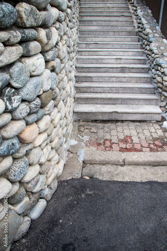stairs and wall from pebble rock stone. Beautiful rock stairs and rock wall with cement steps  architecture from natural materials concept