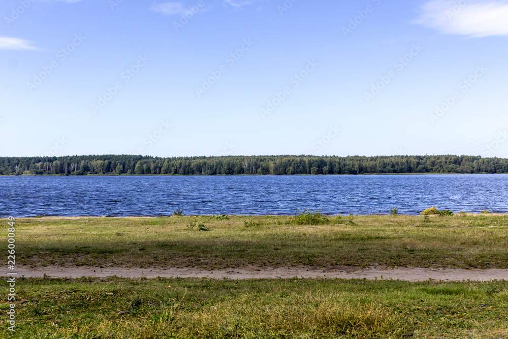 Early autumn. Sunny day. The Volga River near Konakovo. Dense forest on the shore. Tver Region, Central Russia.A background for the site about travel.