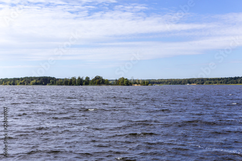 Early autumn. Sunny day. The Volga River near Konakovo. Dense forest on the shore. Tver Region, Central Russia.A background for the site about travel.