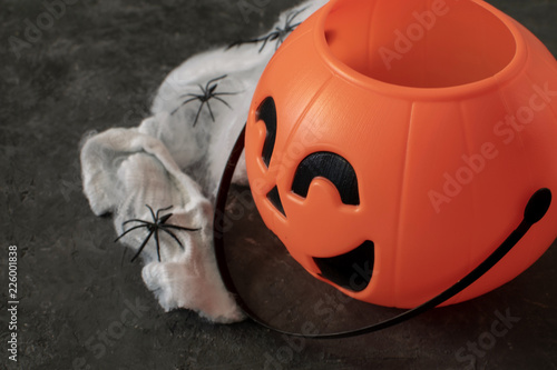 Halloween decoration concept - Trick o treat bag close up in shape pumpkin, spiders on web. photo