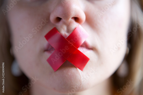 The girl’s mouth is sealed with tape.