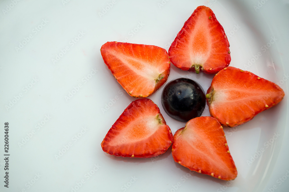 Top view of grapes and strawberries star shape on a white plate. Healthy and beauty fruits concept. Colorful of nature fresh fruits. Health food good life. Eating fruits. Berries vitamin C. Top view of grapes and strawberries star shape on a white plate. Healthy and beauty fruits concept. Colorful of nature fresh fruits. Health food good life. Eating fruits. Berries vitamin C.