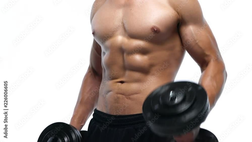 Man flexes his hands with dumbbells, training his biceps on a white background in the studio Man flexes his hands with dumbbells, training his biceps on a white background in the studio