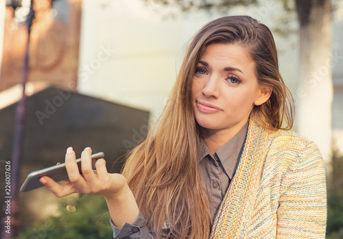 Φωτογραφία annoyed sad woman with mobile phone standing outside in the street