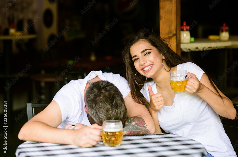 Best friends or lover drink beer in pub. Couple in love on date drinks  beer. She
