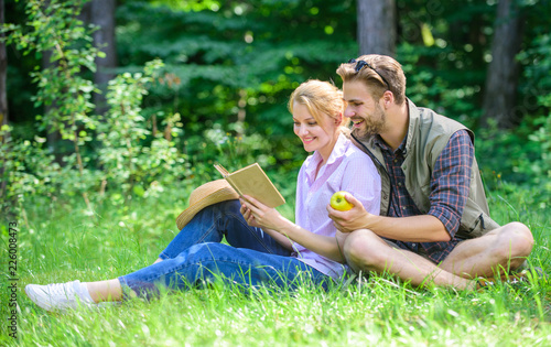 Romantic date at green meadow. Couple in love spend leisure reading book. Romantic couple students enjoy leisure with poetry nature background. Couple soulmates at romantic date. Pleasant weekend