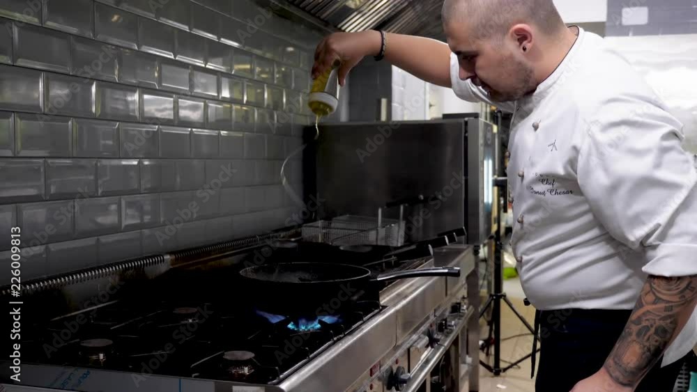 Pouring oil over a pan with shrimps and seafood in restaurant kitchen Pouring oil over a pan with shrimps and seafood in restaurant kitchen