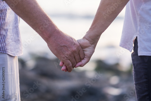 concept of vacation, tourism, travel and people - happy senior couple holding hands. Moment of relaxation and serenity with ethernal foreverness love between aged people after an entire life together