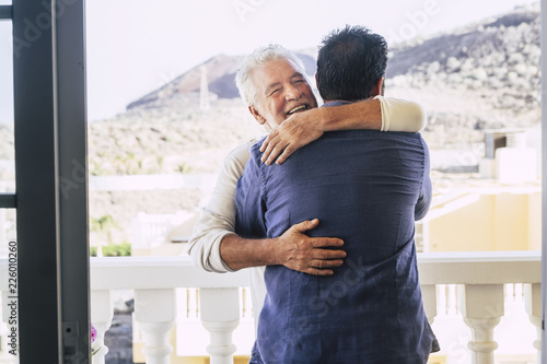 couple of men different ages like father and son adults hug with love and family relationship outdoor in the terrace at home. caucasian people hugging and stay happy together. Father's day concept photo