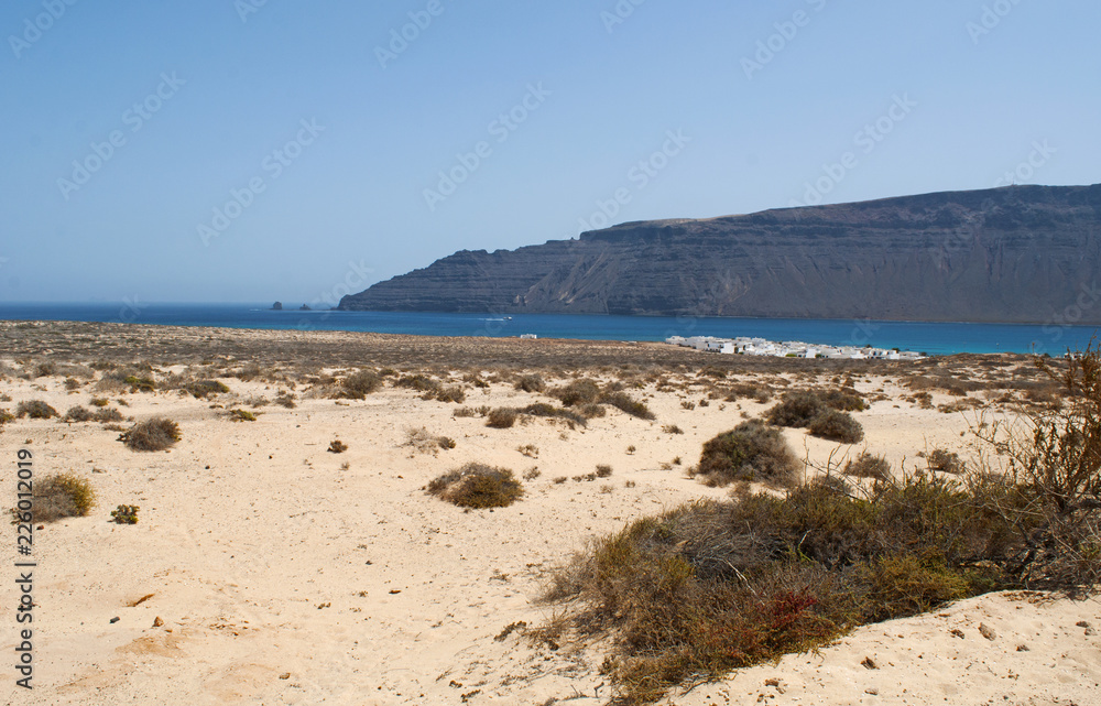 Lanzarote, isole Canarie: l'enorme scogliera Riscos de Famara nel nord-ovest di Lanzarote vista da La Graciosa, la più grande isola dell'arcipelago di Chinijo