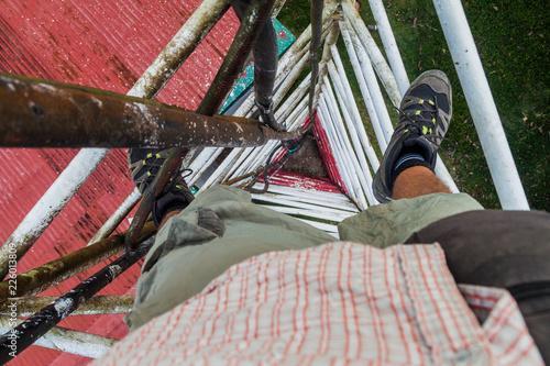 Person climbing a triangular guyed lattice mast near Santa Elena village, Costa Rica