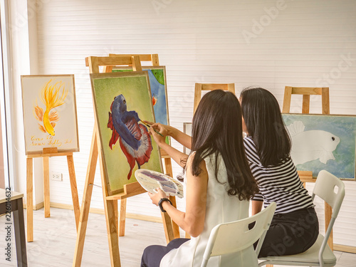 Two young asian woman artist dawning while useing ideas to think and create the best artwork together,fish concept photo