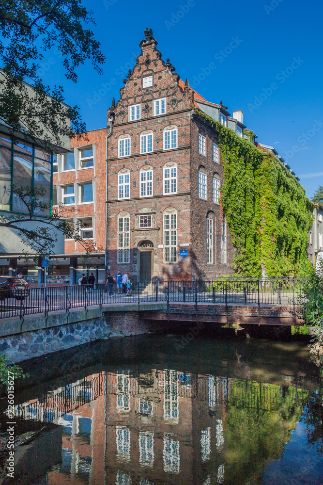 Naklejka premium GDANSK, POLAND - SEPTEMBER 1, 2016: Reflection of a brick house in a canal in Gdansk, Poland