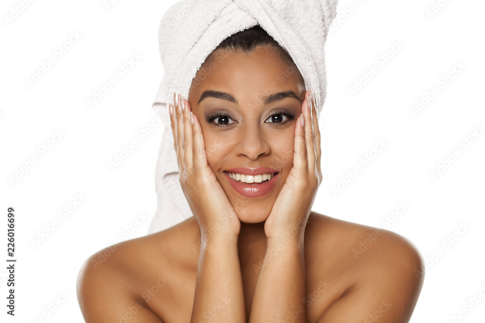 portrait of young beautiful happy dark-skinned woman with towel on her head, posing on a white background portrait of young beautiful happy dark-skinned woman with towel on her head, posing on a white background