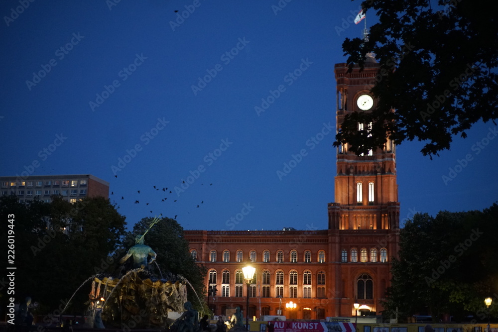 Fototapeta premium The red city hall (Rotes Rathaus) with the Neptune Fountain ( Neptunbrunnen) , Alexanderplatz in Berlin
