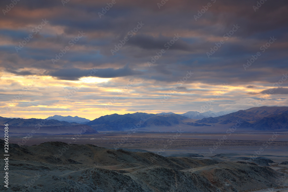 Landscape of highland steppe with mountains cloudy dramatic blue sky in beautiful sunrise at Bayan-Ulgii, Mongolia