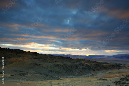 Landscape of highland steppe with mountains cloudy dramatic blue sky in beautiful sunrise at Bayan-Ulgii  Mongolia