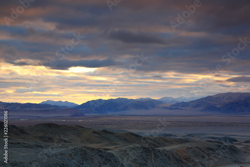 Landscape of highland steppe with mountains cloudy dramatic blue sky in beautiful sunrise at Bayan-Ulgii, Mongolia © isarescheewin
