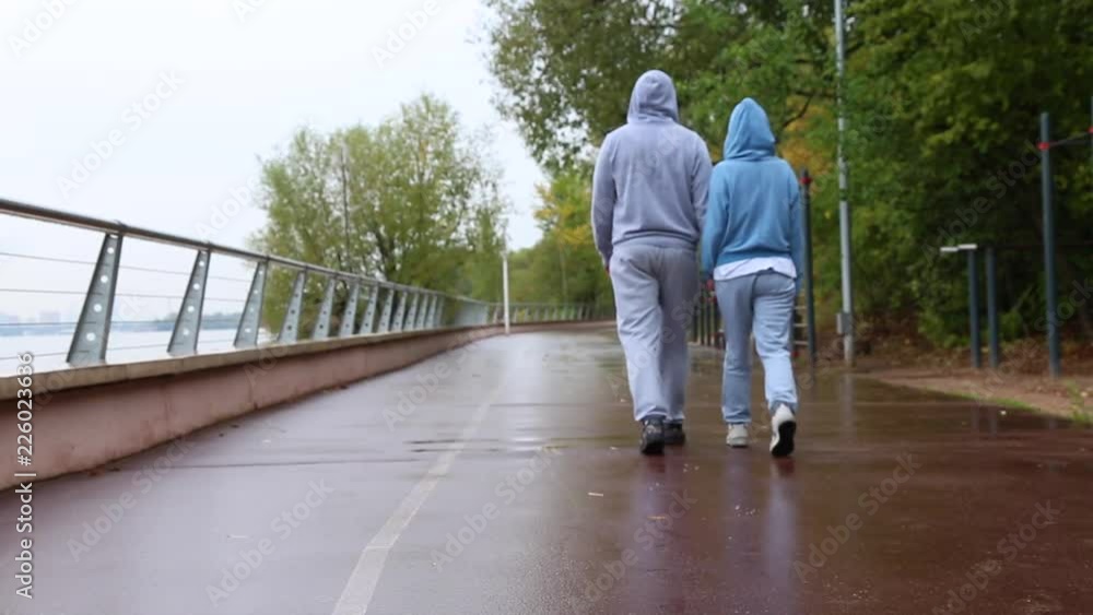 Back view of young couple walking in nature, park together. Man and woman walking and hold hands. Back view of young couple walking in nature, park together. Man and woman walking and hold hands.