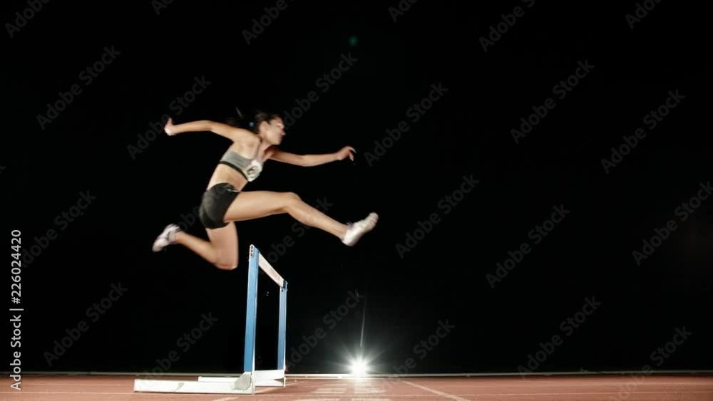 Runner heading forward. Young female athlete blasting off on short track of stadium and jumping over barriers, training before olympics 4k Runner heading forward. Young female athlete blasting off on short track of stadium and jumping over barriers, training before olympics 4k
