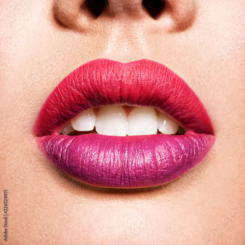 beautiful woman lips with  red and purple lipstick.