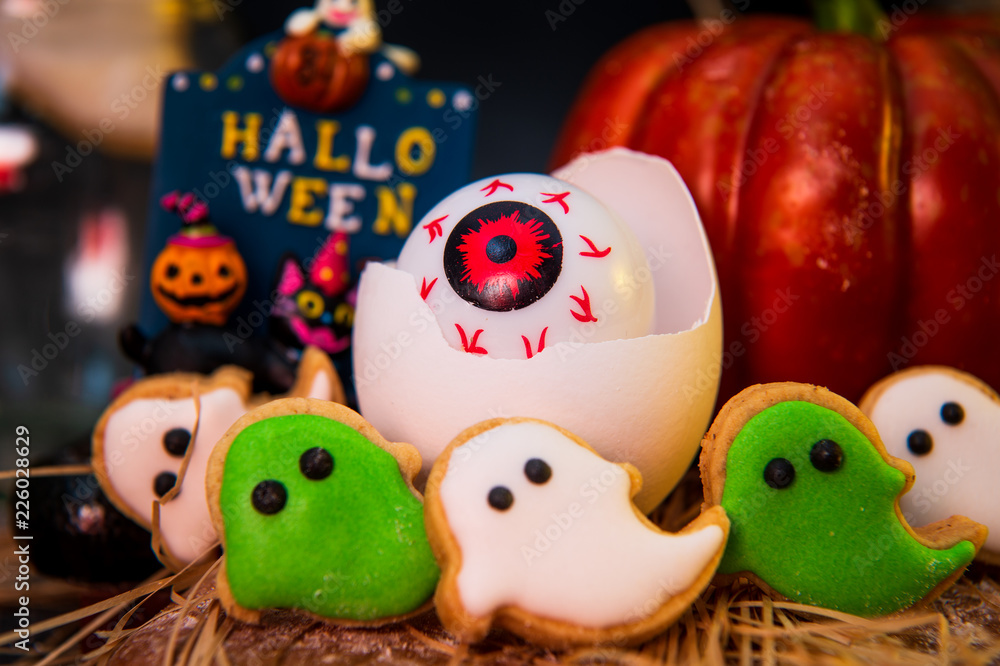 Fresh homemade decorated halloween cookies and sweets on dark background, concept of halloween monster party, copy space, close up