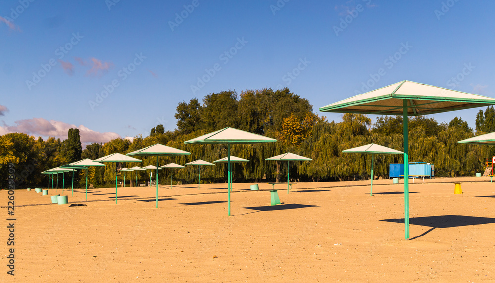 Beach umbrellas and deserted sandy beach in the early morning