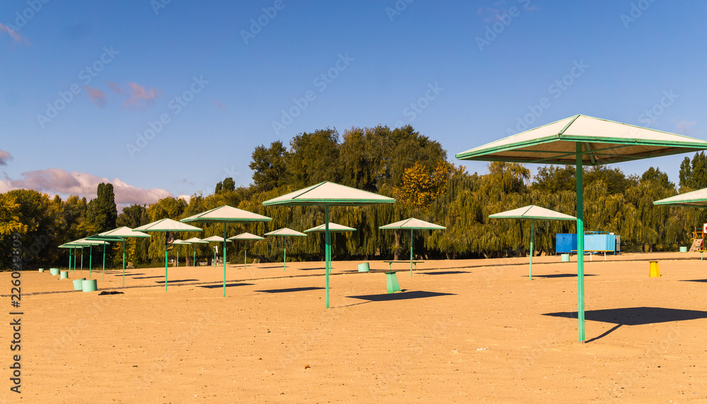 Beach umbrellas and deserted sandy beach in the early morning Beach umbrellas and deserted sandy beach in the early morning