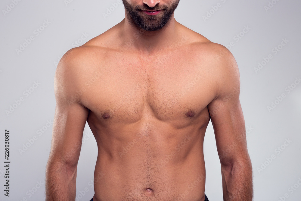 Perfection. Part of handsome shirtless young man standing against white background - obrazy, fototapety, plakaty 