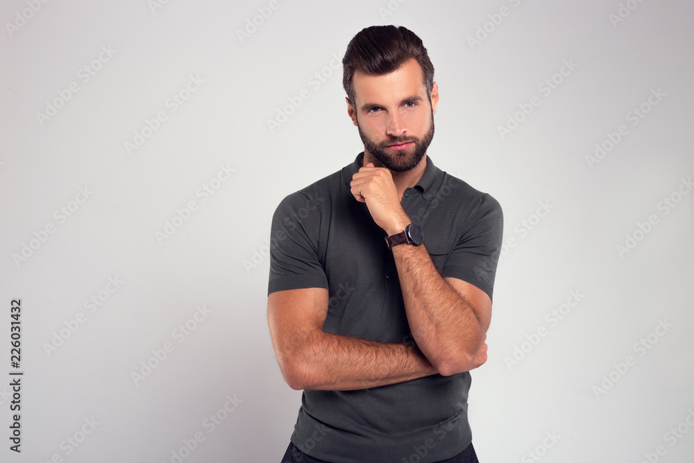 His attitude. Handsome young man looking at camera while standing against white background His attitude. Handsome young man looking at camera while standing against white background