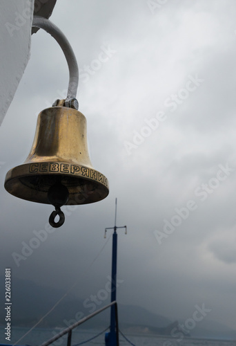 Russia, Lake Baikal, Jul, 21 2018: Ship bell and mast. The largest lake in rainy weather photo