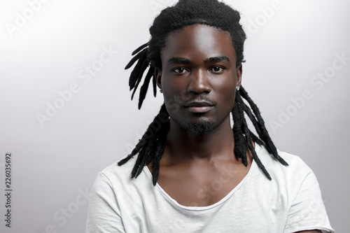 African American male with dreadlocks on white background looking at camera photo