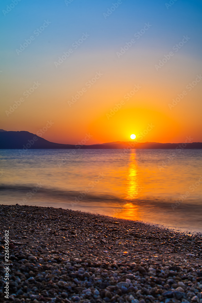 Naklejka premium Early morning , dramatic sunrise over sea and mountain. Photographed in Asprovalta, Greece.