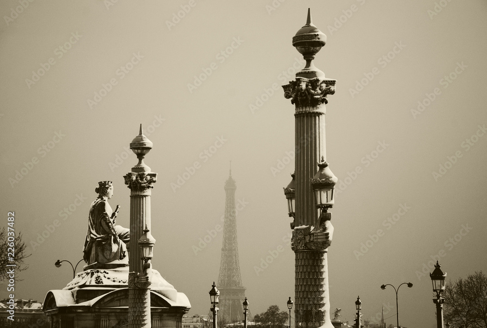 Paris (France) in winter. Place de la Concorde covered with snow and Eiffel tower seen at background in rare snowy  day. Sepia photo.