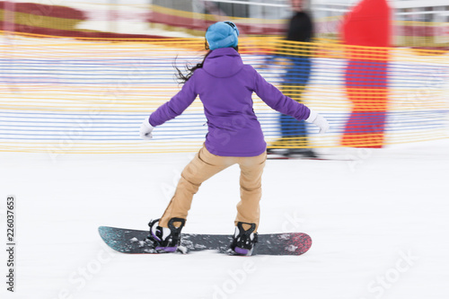 Girl snowboarding from the mountain in winter