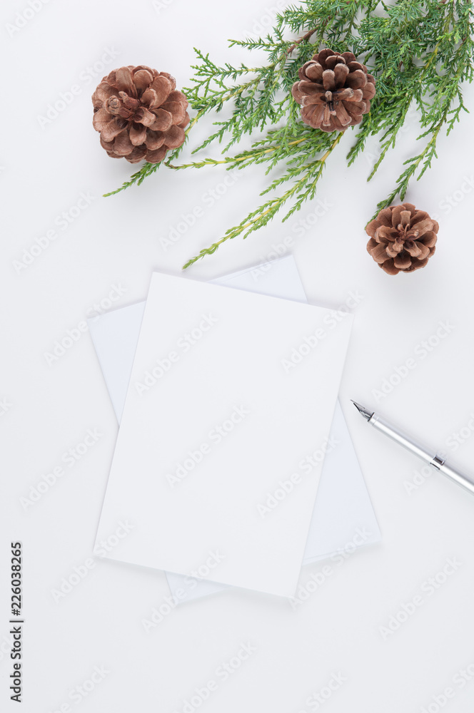 pen and stationary mockup on a white background with christmas greenery and pine cones pen and stationary mockup on a white background with christmas greenery and pine cones