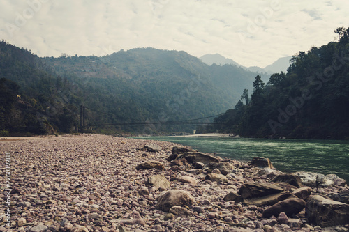 A beautiful landscape in the mountains with a bridge over the Ganges River