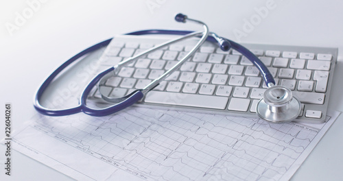Stethoscope lying on a laptop keyboard in a concept of online m