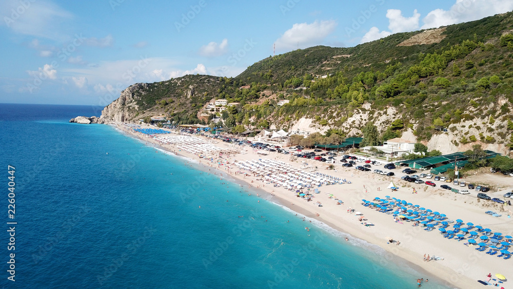 Aerial top view photo of sun beds in popular tropical paradise deep turquoise sandy beach of Kathisma, Lefkada island, Ionian, Greece
