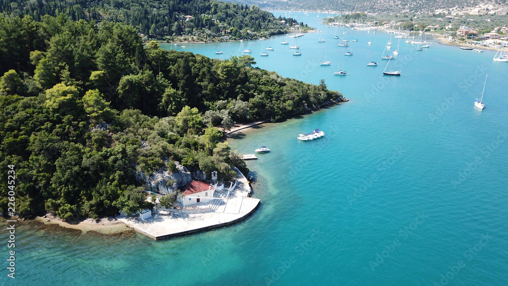 Obraz premium Aerial drone bird's eye view photo of iconic port of Nidri or Nydri a safe harbor for sail boats and famous for trips to Meganisi, Skorpios and other Ionian islands, Leflkada island, Ionian, Greece