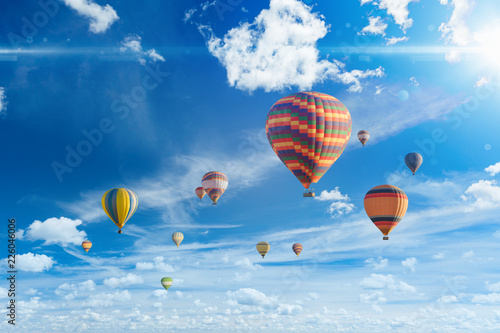 Fototapeta Naklejka Na Ścianę i Meble -  Colorful hot air balloons fly in blue sky with white clouds and bright sunshinr