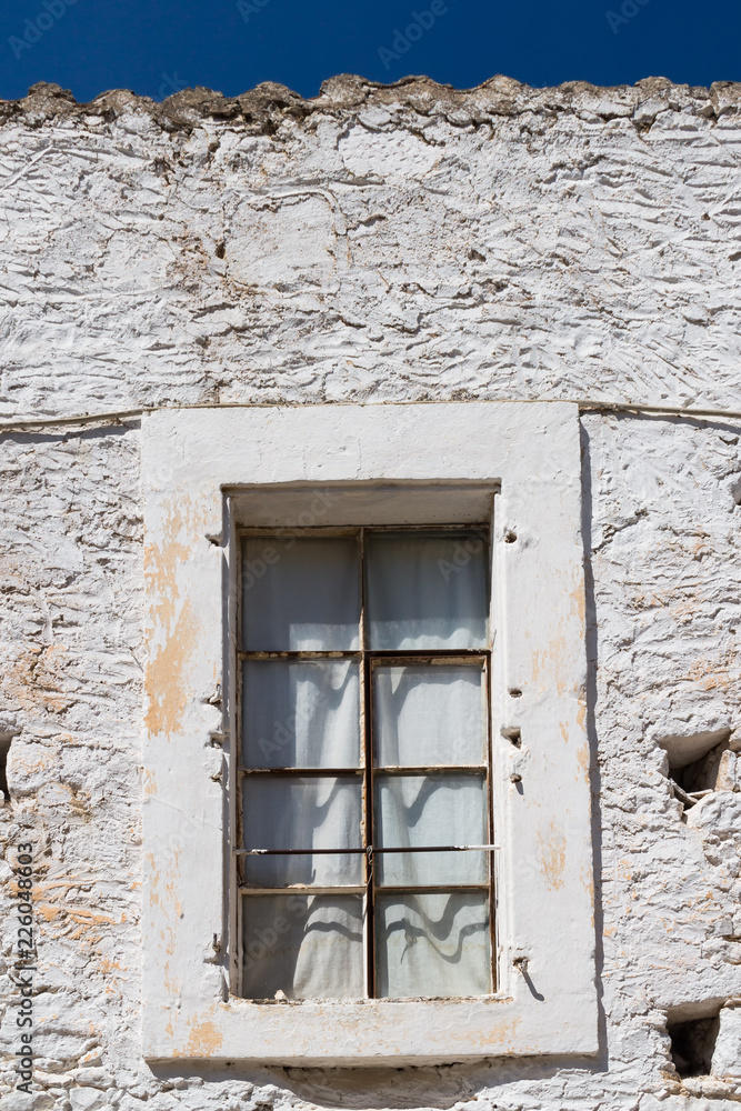 Window and a white stone wall, Greece
