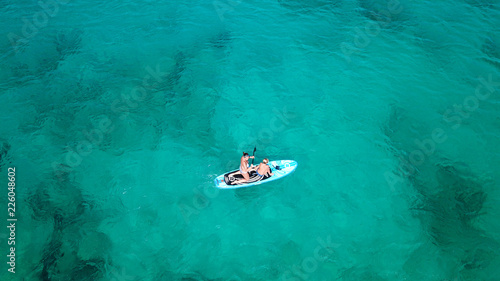 Aerial drone photo of couples practicing Stand Up Paddle or SUP in famous watersports beach of Agios Ioannis, Lefakada island, Ionian, Greece
