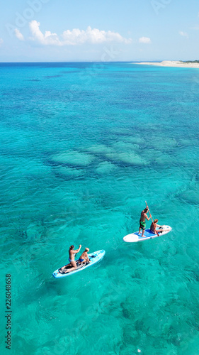 Photography Aerial drone photo of couple practicing Stand Up Paddle or SUP in tropical exoti