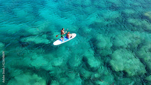 Obraz na płótnie Aerial drone photo of couple practicing Stand Up Paddle or SUP in tropical exotic emerald and sapphire island sea w salonie